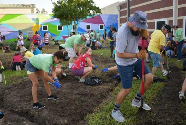 澳门足彩app team members landscaping the front of a middle school.